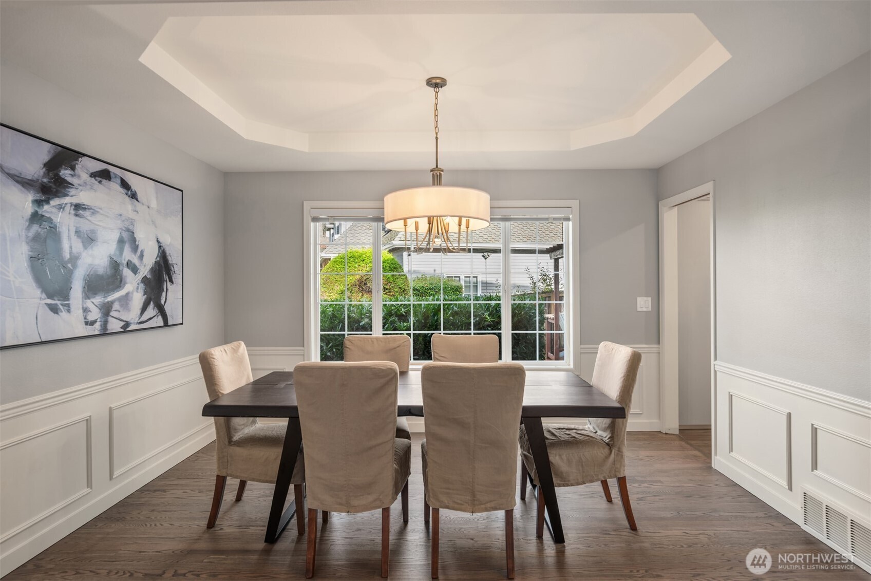 Dining room features wainscotting, coved ceiling and territorial outlook to backyard.