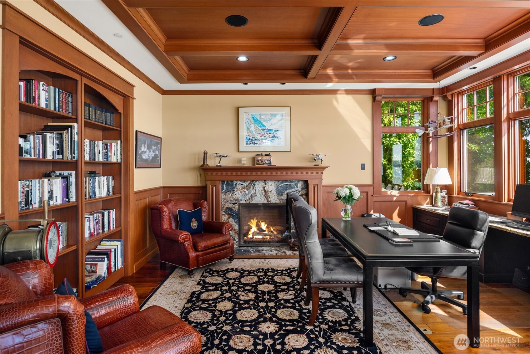 Fabulous executive office with sliding bookshelves to an additional private room with windows and a fireplace of it's own.