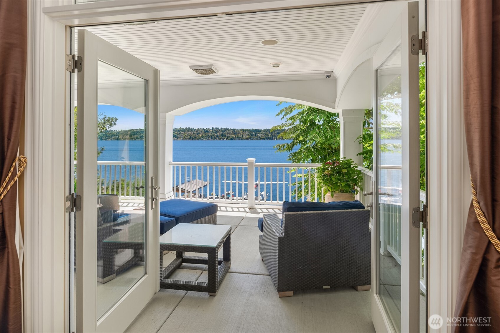 Lower deck has outdoor fireplace and sitting area with TV and speakers along the entire deck.