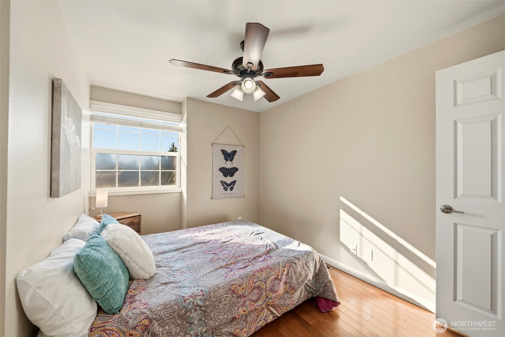 Comfortable bedroom with ceiling fan and large window providing abundant natural light.