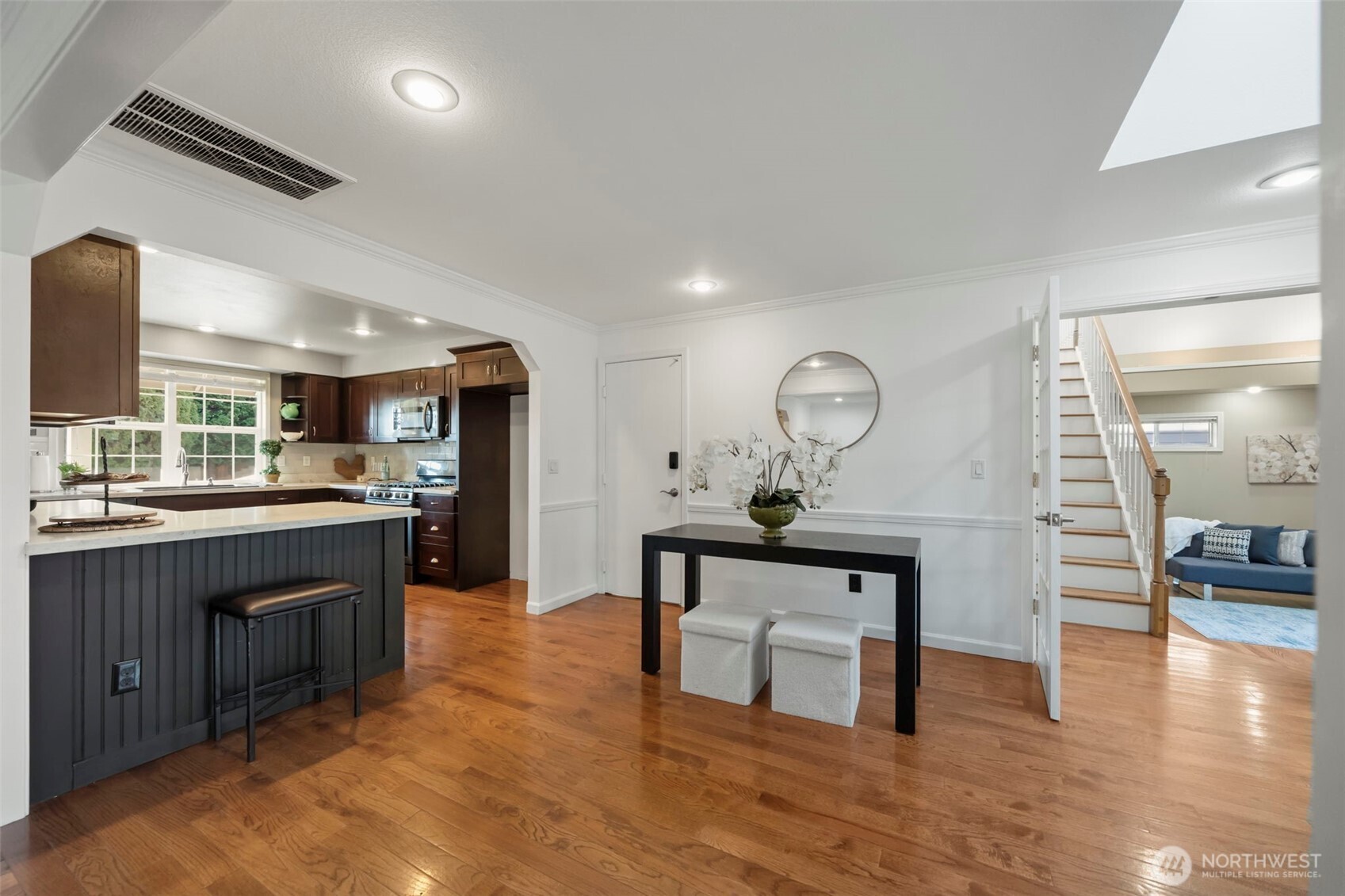 The dining area connects seamlessly with the kitchen, where bar seating and a casual eating space create an inviting hub for meals, conversation, and entertaining.