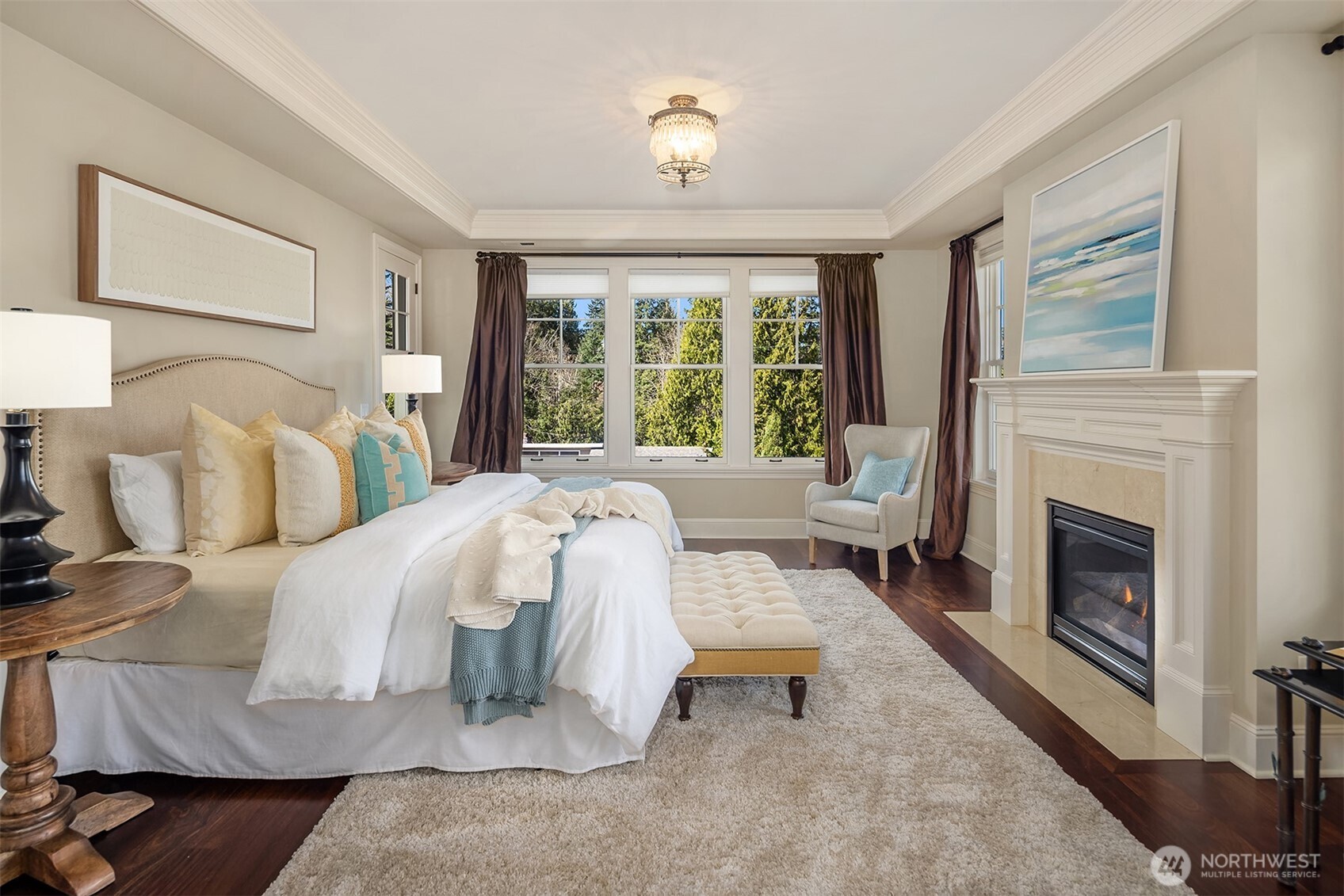 Primary bedroom with lake views and fireplace.