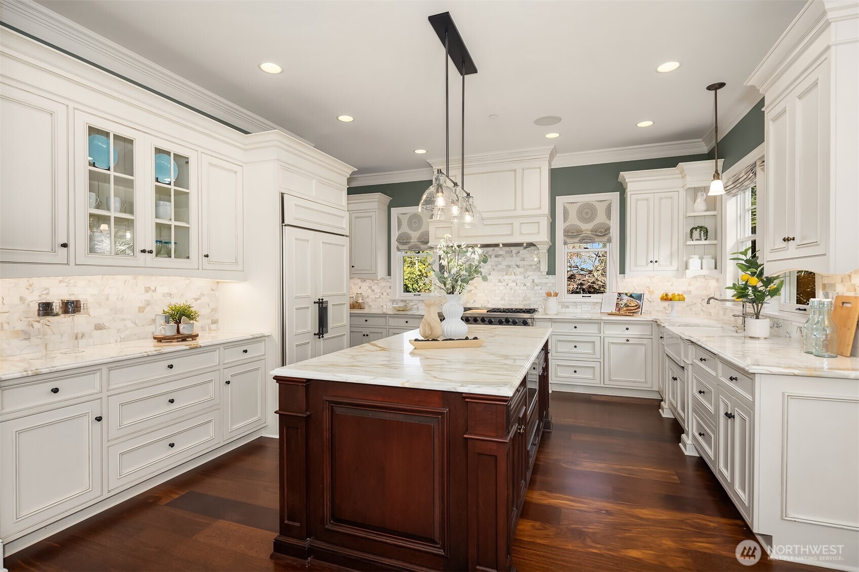 Grand inviting chefs kitchen with a built-in SubZero filled with natural light and abundant counter space.