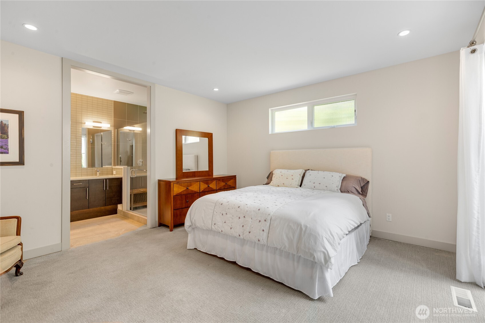 A sumptuous primary bedroom on the main floor with a seating area, spa-like bathroom, walk-in closet and sliders to the private patio and fully fenced yard.