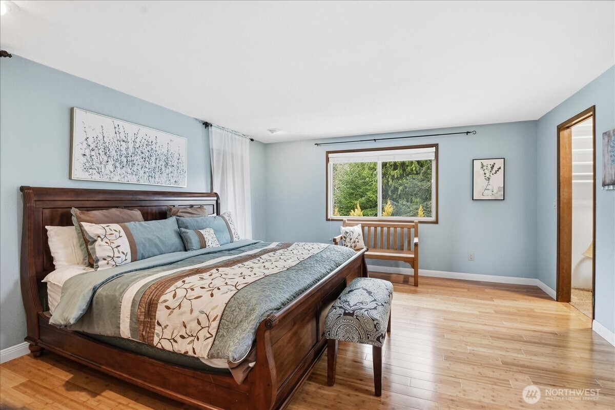 Spacious primary suite with peaceful outlooks, generous layout, and bonus storage tucked behind the bed wall.