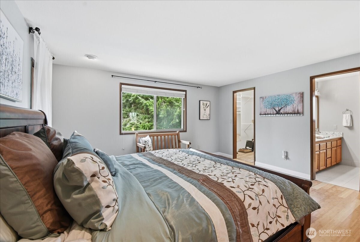 Primary suite with easy access to the ensuite bath, walk-in closet, and peaceful backyard outlooks.