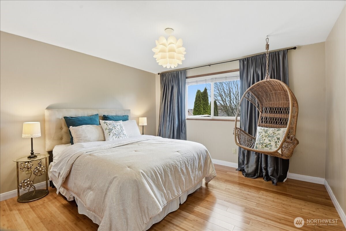 Bright and spacious guest bedroom with hardwood floors and a comfortable, versatile layout.