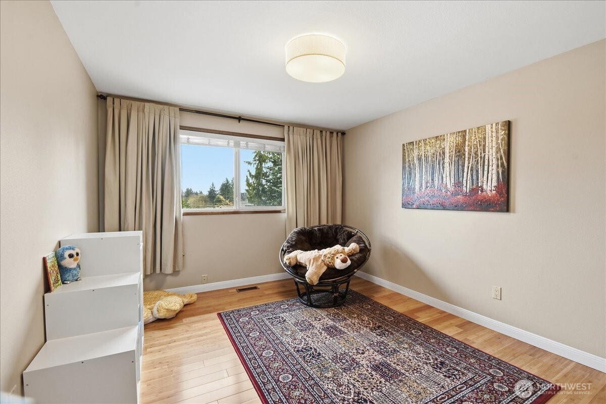 Light-filled guest bedroom with hardwood floors and versatile space to fit your needs.