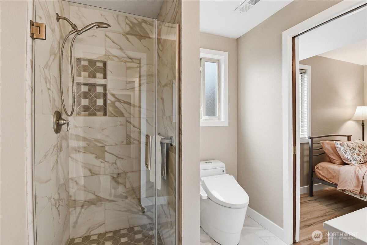 Stylish 3/4 bath with glass-enclosed tile shower and easy access from the adjacent fourth bedroom.