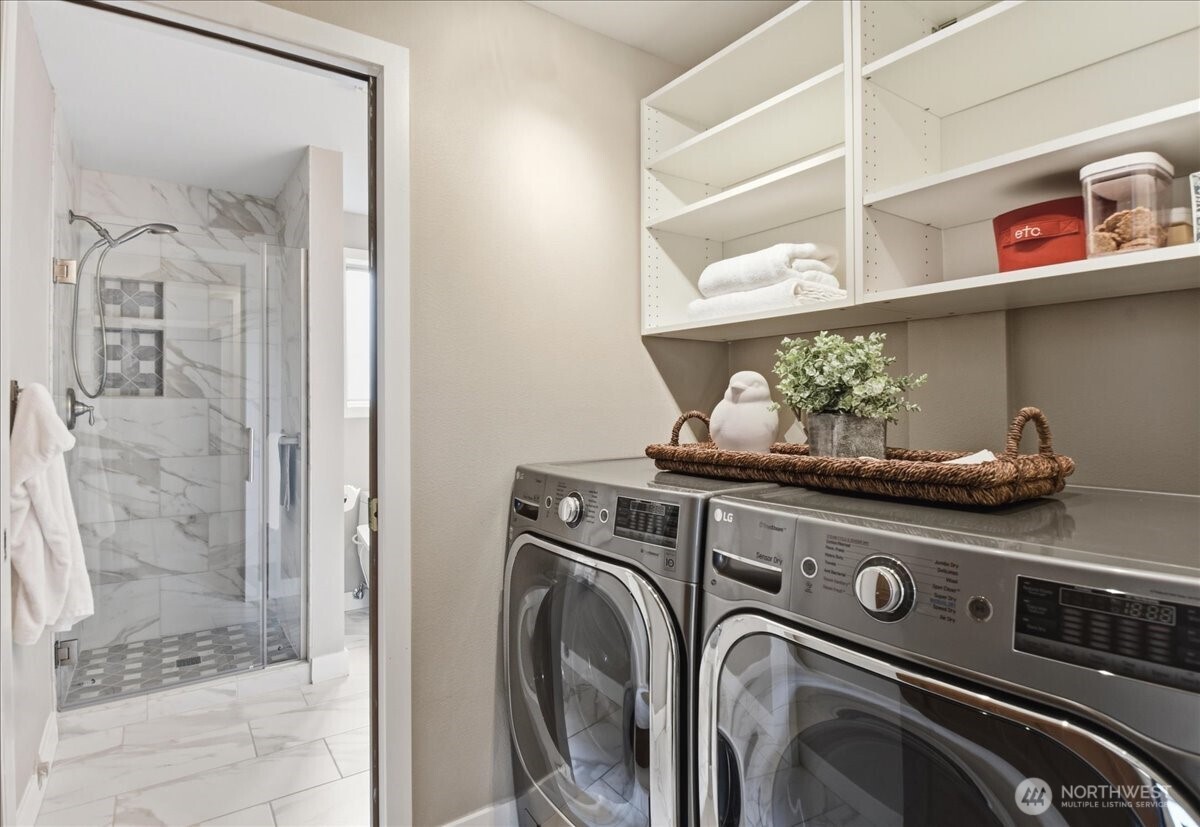 Convenient lower-level laundry area with built-in shelving and easy access to the adjacent 3/4 bath.