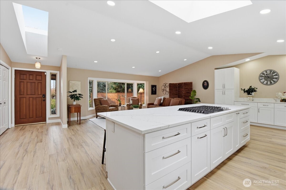 Expansive kitchen and living area with quartz island, skylights, and seamless flow throughout.