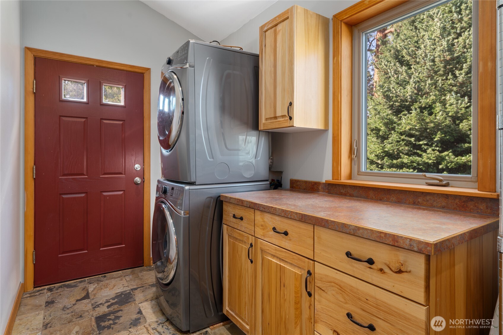 View of main level utility room just off the kitchen. The door leads to the outdoor living area and also features a large adjacent pantry.