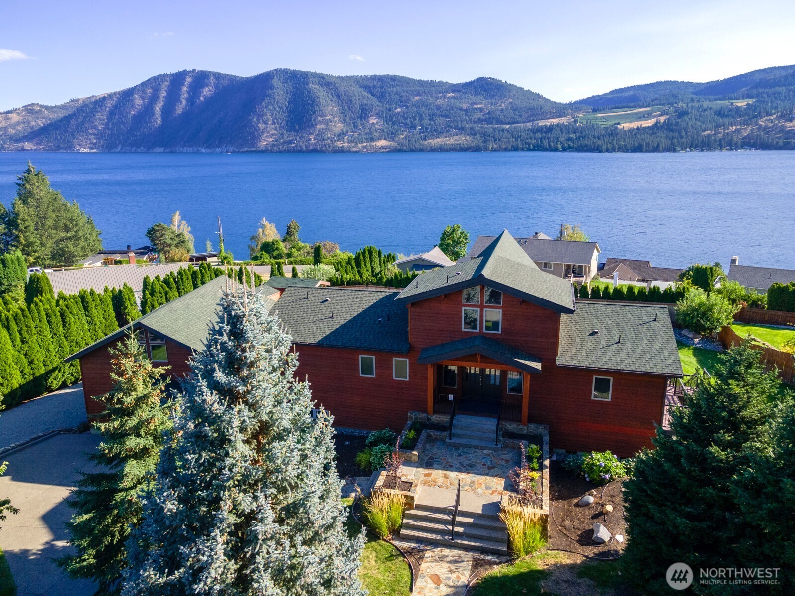 Aerial view of home and carriage house w/ landscaped grounds overlooking Lake Chelan.