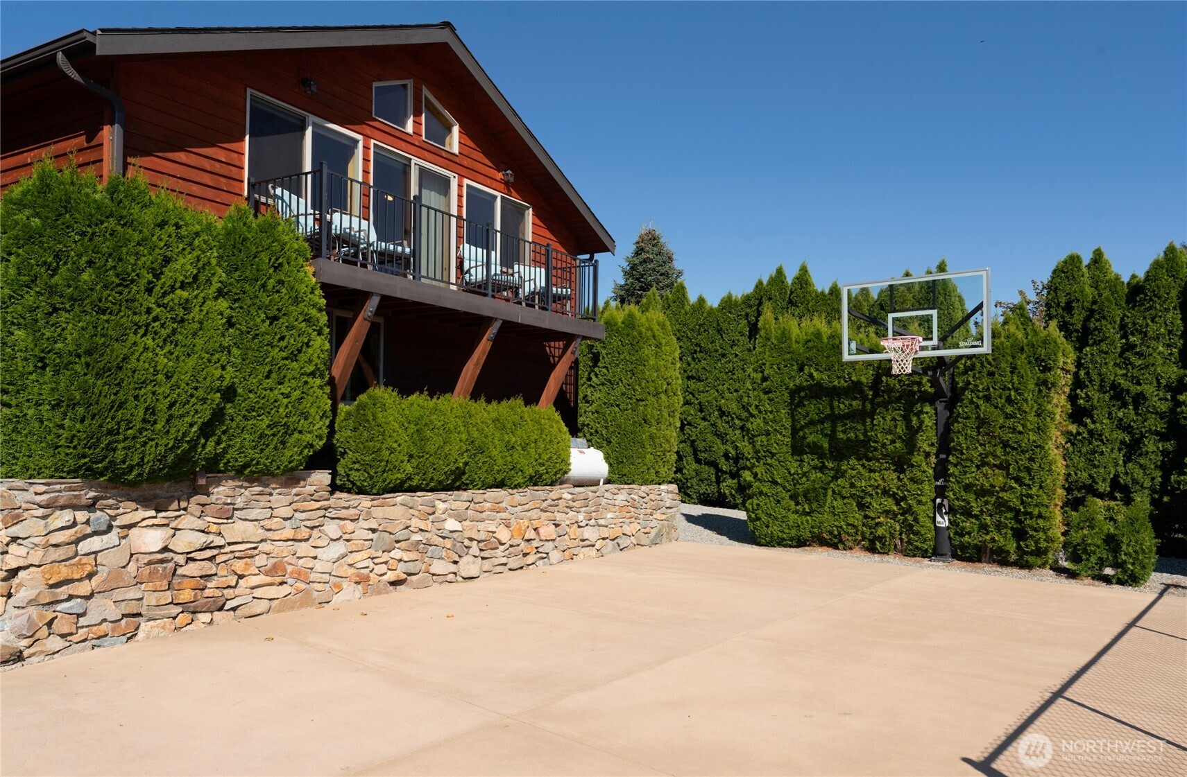 View of detached carriage house w/ view deck and private basketball court.