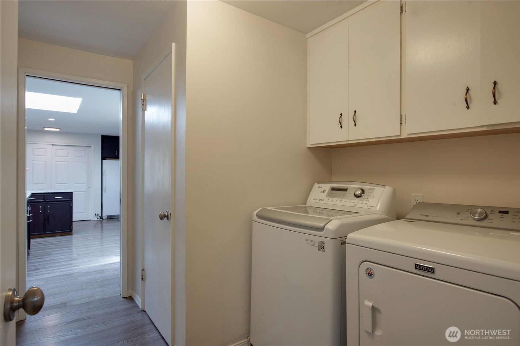 Dedicated laundry space with built in cabinetry, offering convenience, storage,and efficient organization or daily tasks.