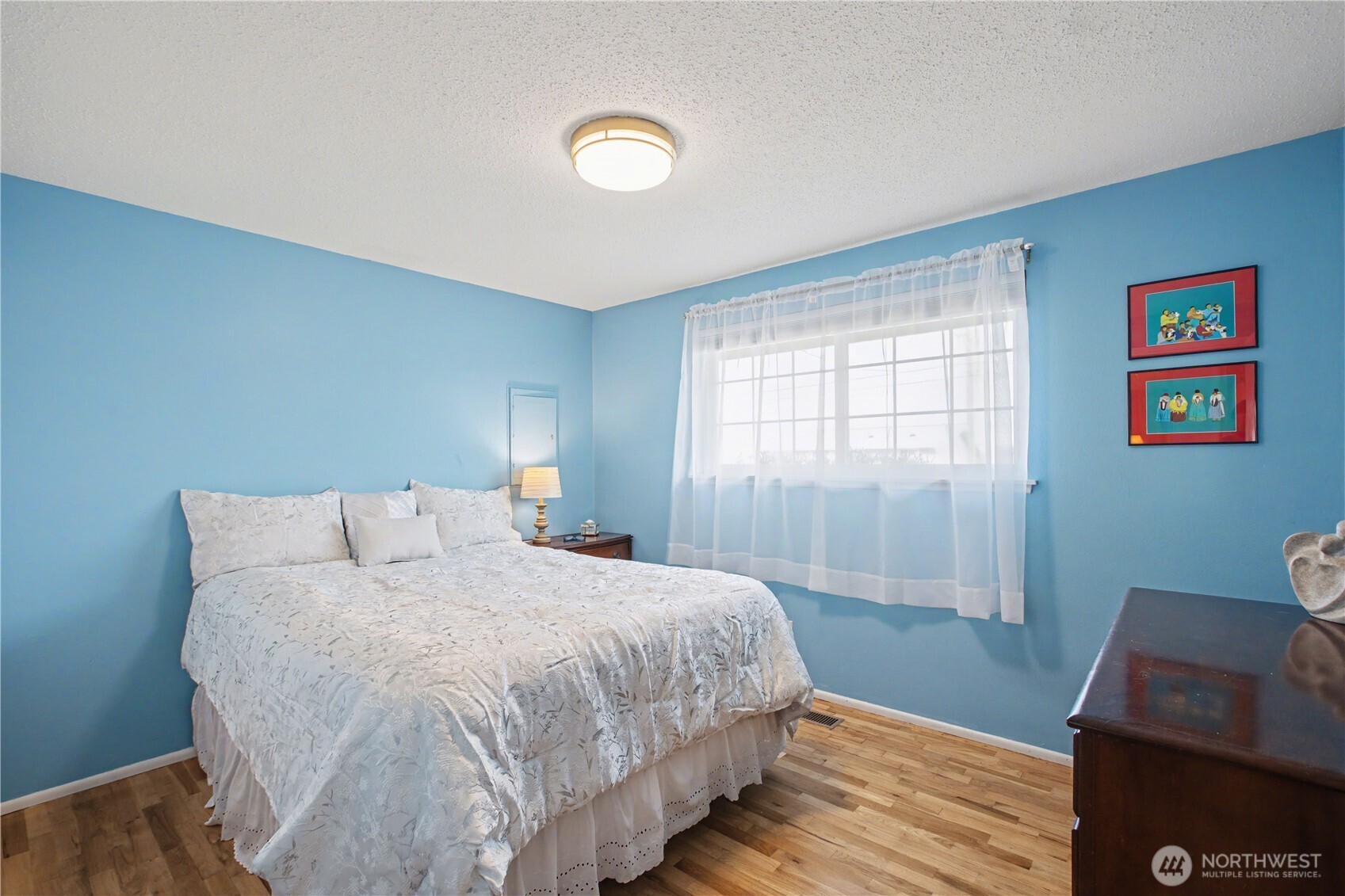 Serene main bedroom filled with natural light, creating a peaceful retreat with generous proportions and a calming ambiance.