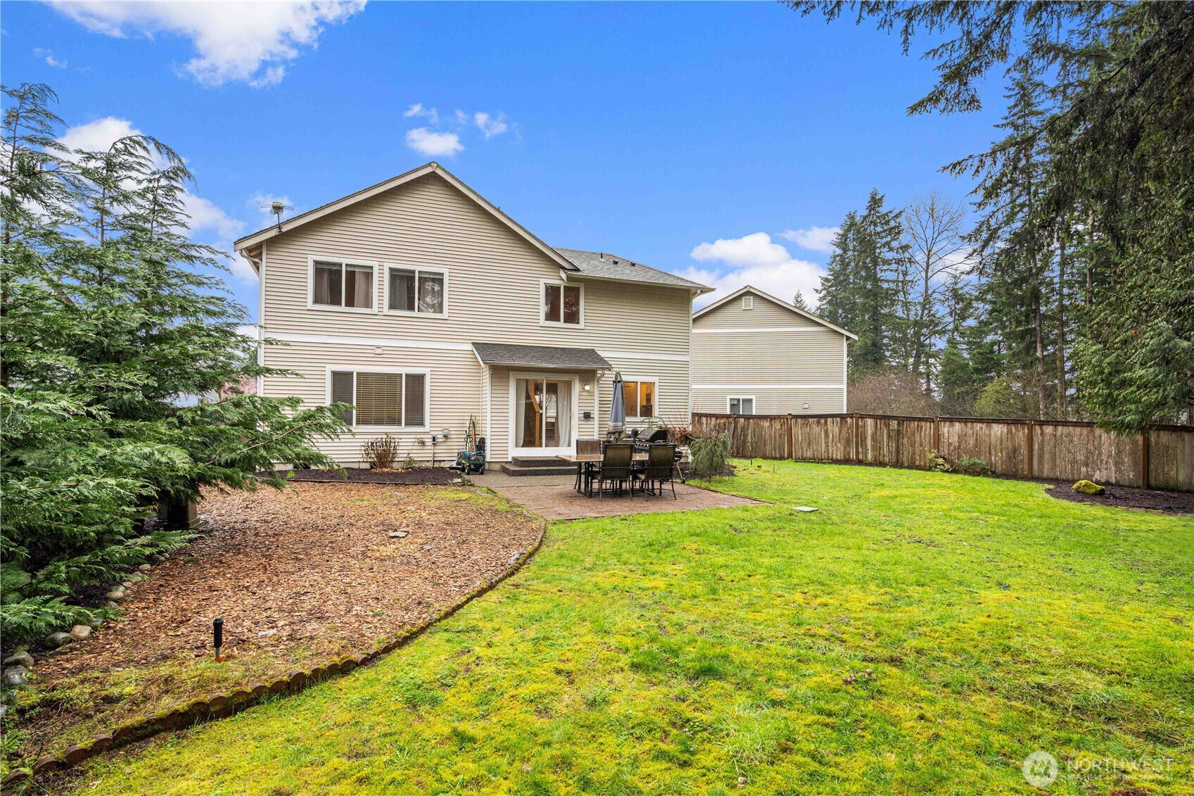 Large backyard with fresh landscaping and recently reseeded lawn, offering a great space for outdoor enjoyment and entertaining.