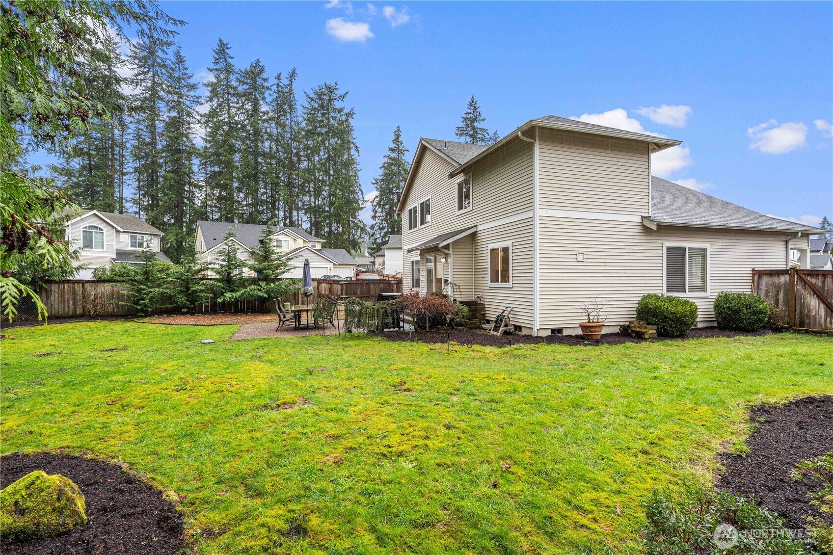 Large backyard with fresh landscaping and recently reseeded lawn, offering a great space for outdoor enjoyment and entertaining.