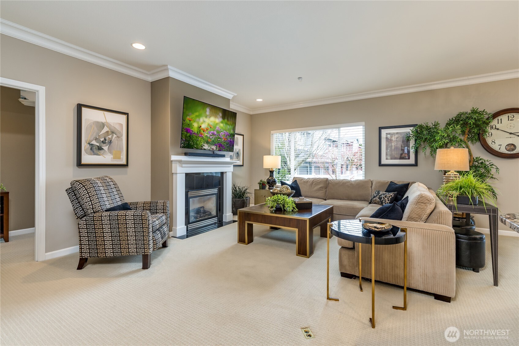 Elegance meets function in the expansive living room, featuring stately crown molding and a cozy gas fireplace