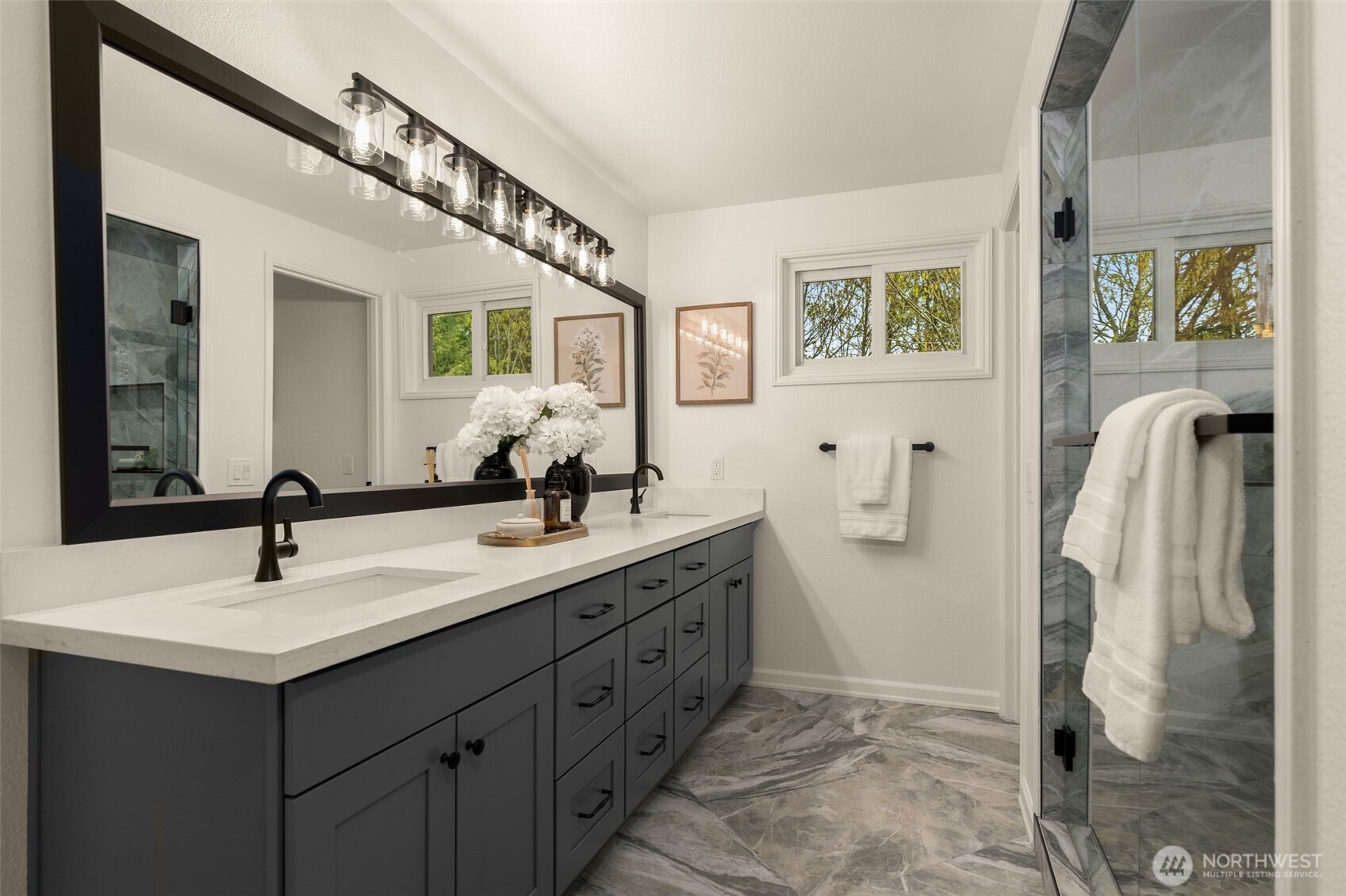 Primary bath en-suite with dual sink vanity boasting sprawling countertop space. Private lavatory.