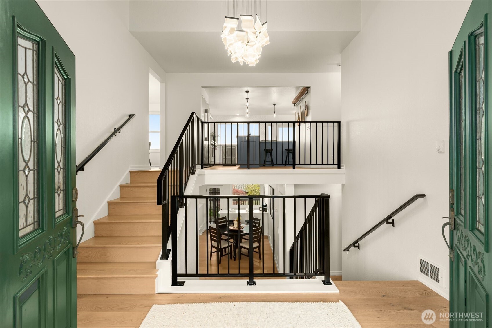 Double doors to grand open foyer with high ceiling line and architectural interest.