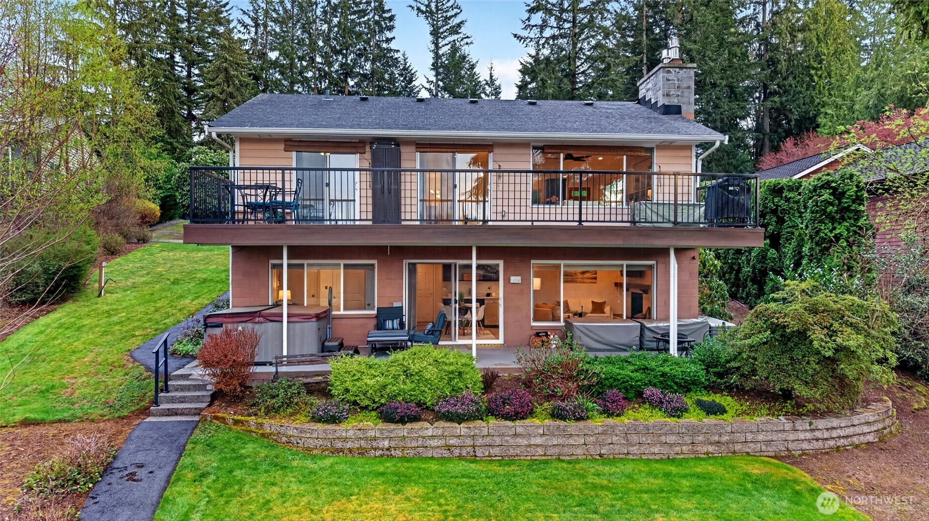Waterfront home with expansive deck, landscaped yard, and seamless indoor-outdoor living on Echo Lake