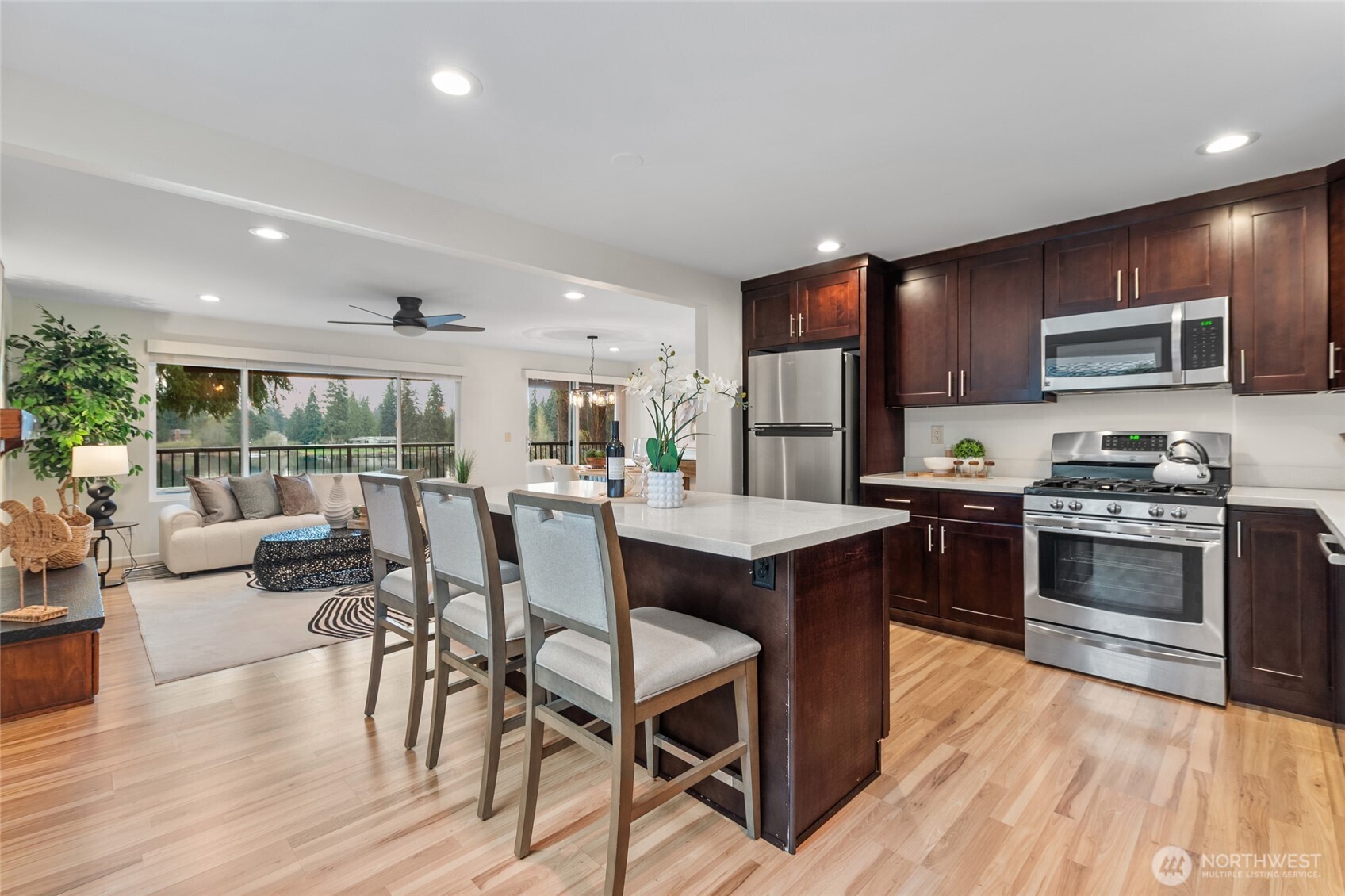 Updated kitchen with quartz countertops, stainless steel appliances, and bar seating