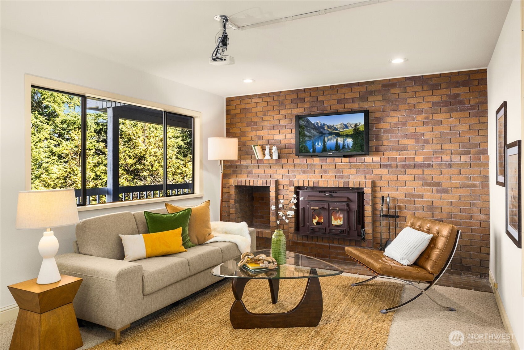 Unwind in the lower level featuring a projector-ready second living room, fireplace, and built-in bar.