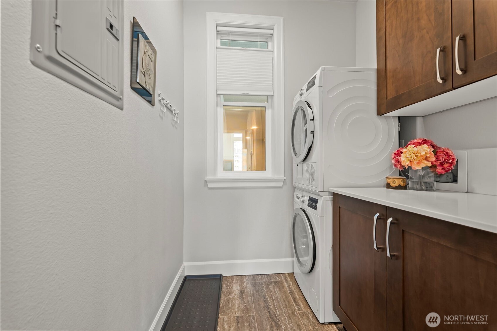 Dedicated laundry room with stacked Bosch washer and dryer, and plenty of storage.
