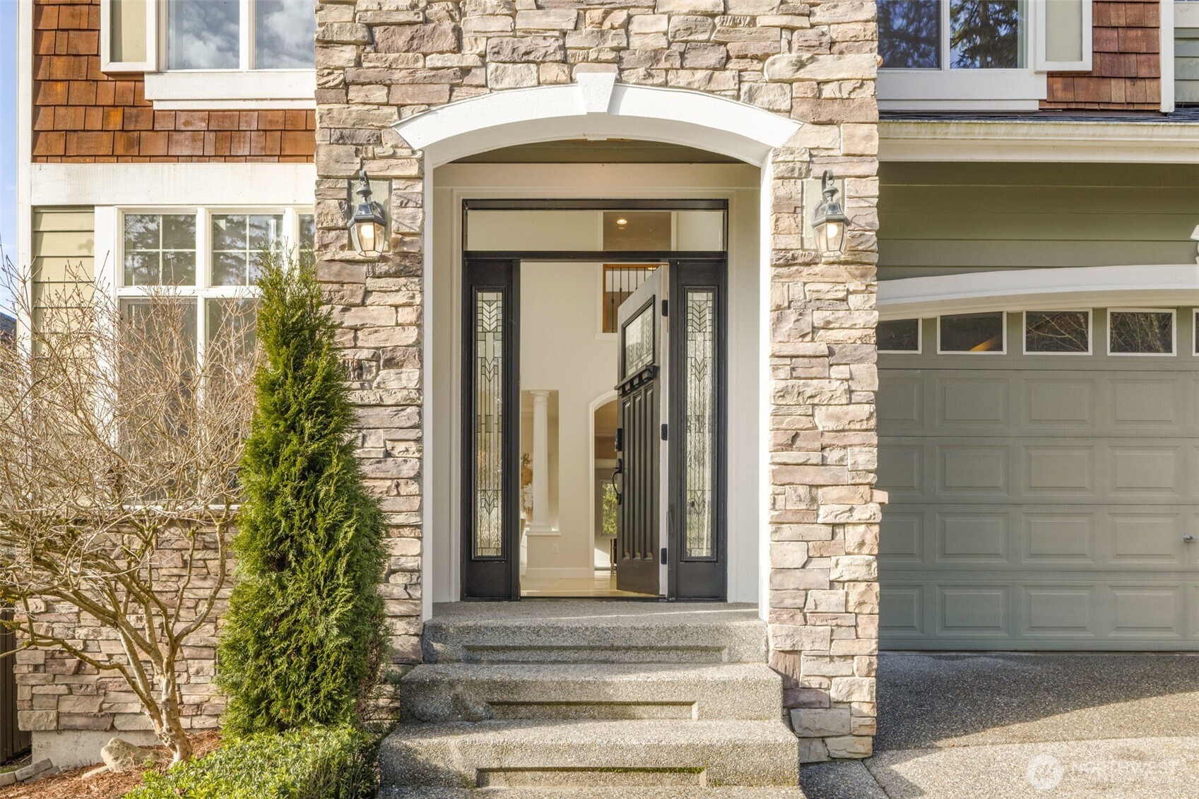 Grand Entry with rich stonework creates an impressive and inviting atmosphere.