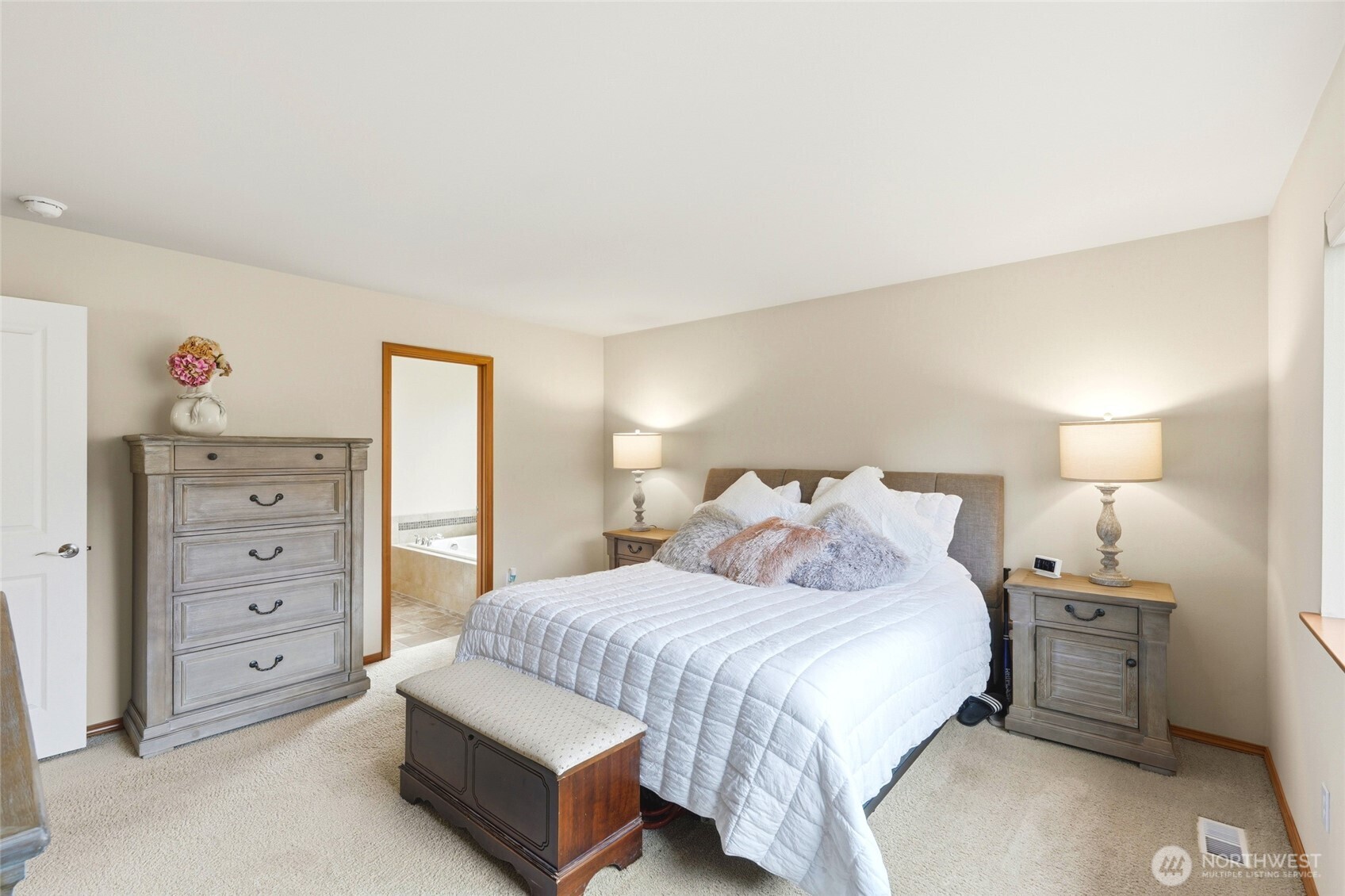 Upstairs, the primary suite overlooks the greenbelt and includes a five-piece bath with soaking tub and a spacious walk-in closet.