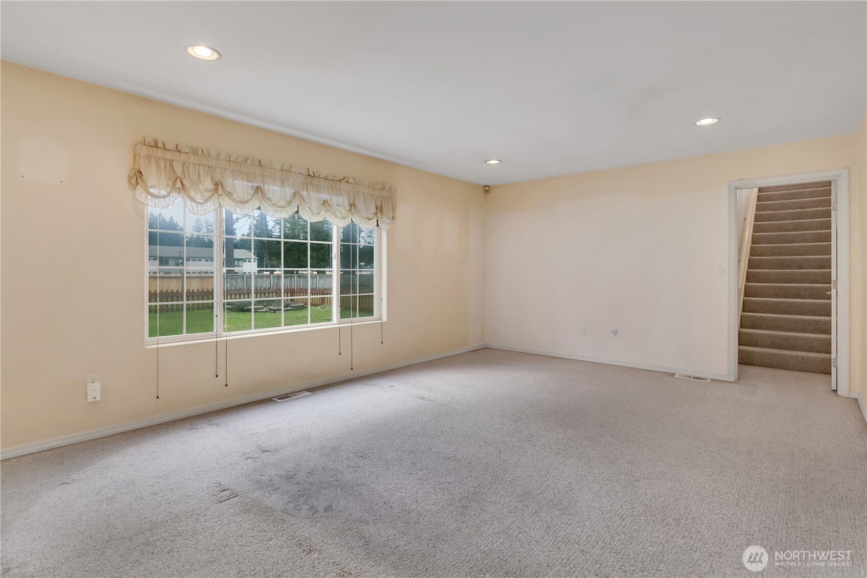 Family room with rear staircase leading up to the bonus room