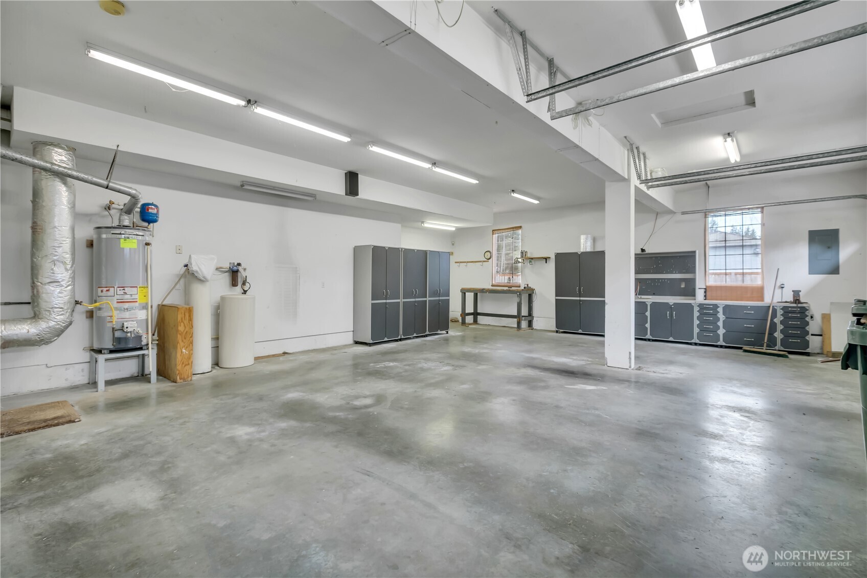 Spacious garage with workbenches and storage cabinets