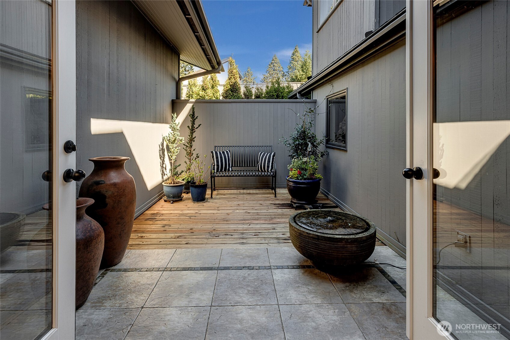 Just beyond, a peaceful courtyard with a fountain provides a private outdoor retreat, ideal for al fresco dining, container gardening, or simply enjoying a cool, shaded escape on warm summer days.