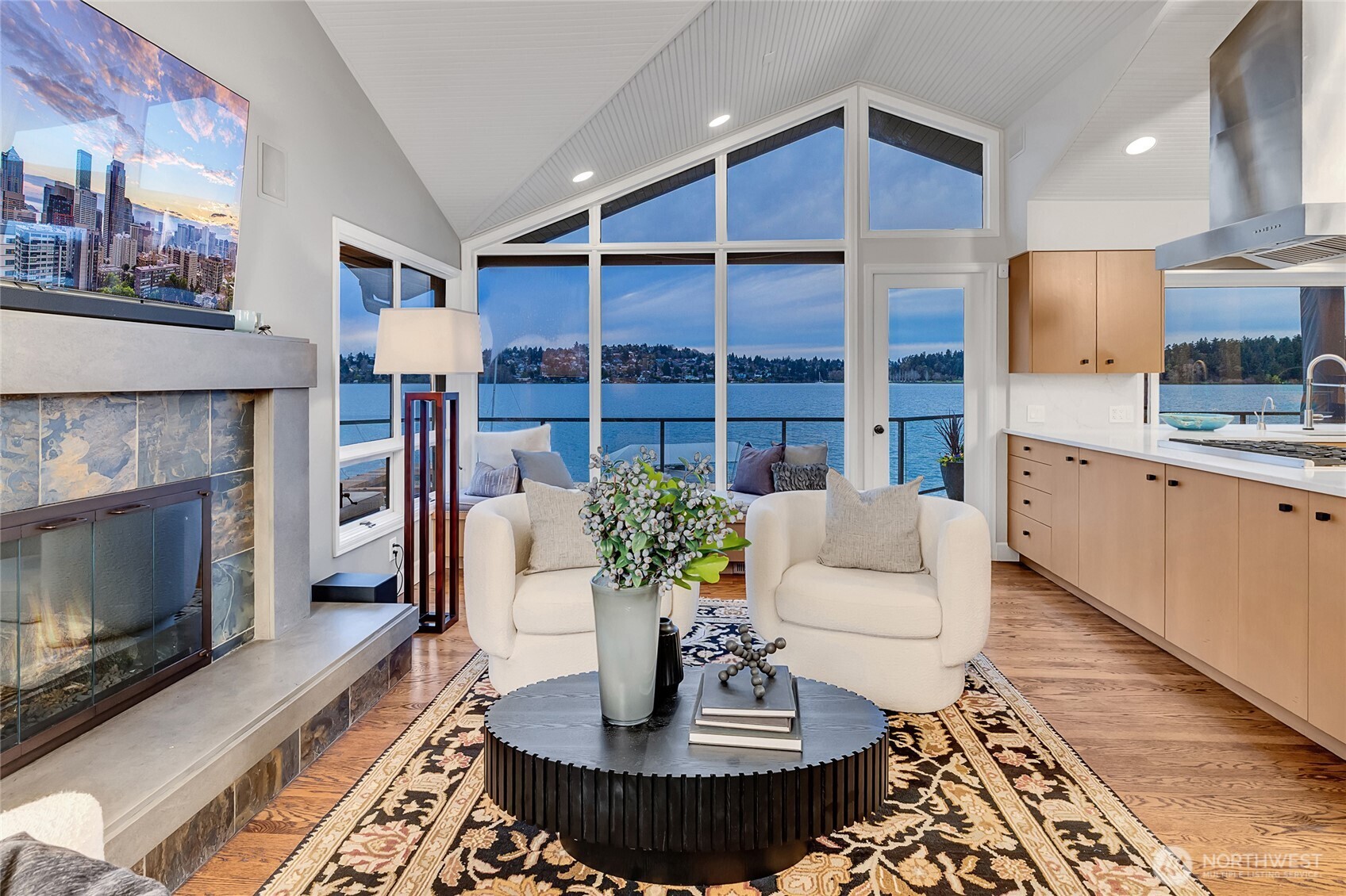 The adjoining family room is anchored by a cozy fireplace, while slab quartz countertops and designer lighting add a refined touch.