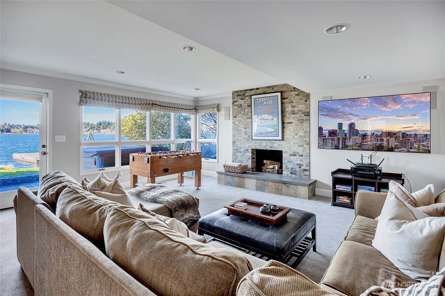 The lower level bonus room is designed for pure enjoyment, perfectly positioned just off the lake for easy access to the outdoors. A cozy fireplace anchors the space, creating the ideal setting for movie nights