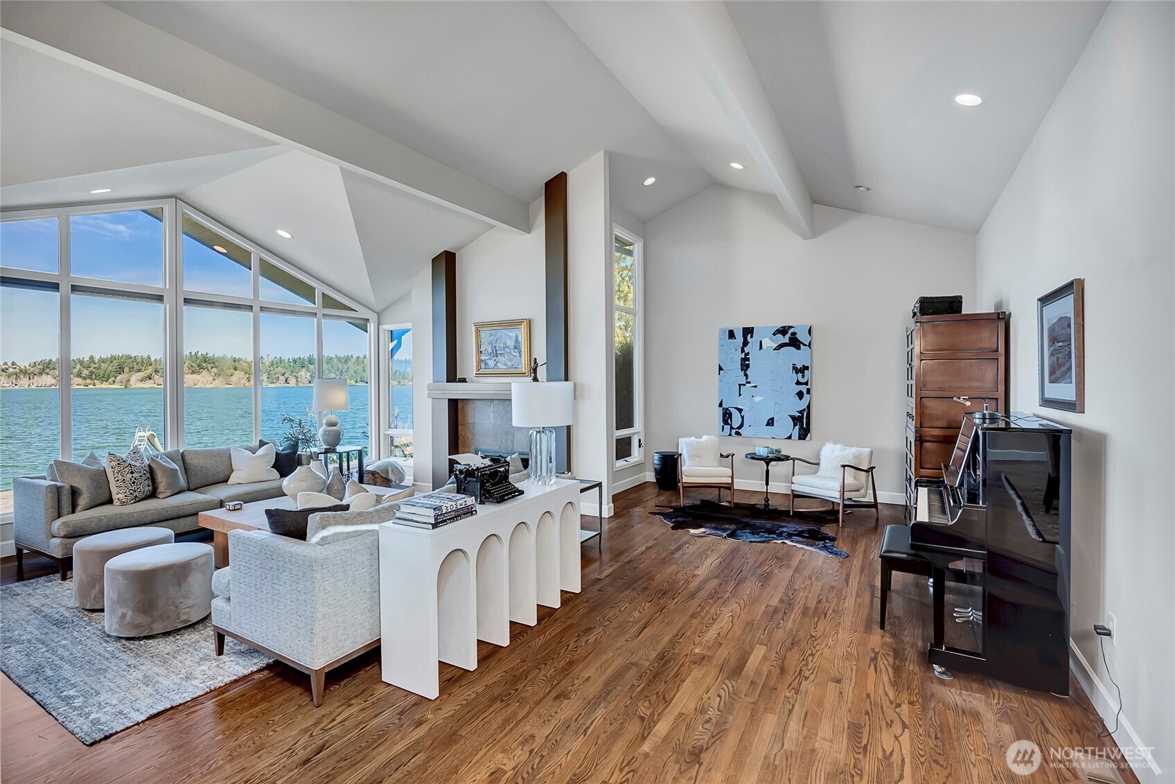The living room is defined by vaulted ceilings and walls of glass that frame seemingly endless views, filling the space with light and a sense of openness.