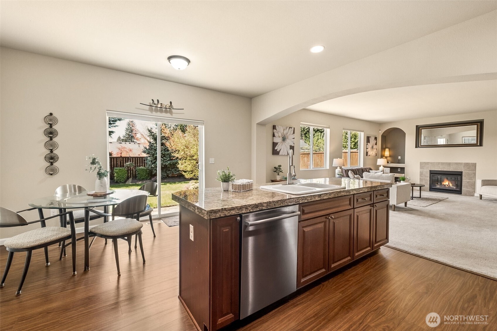 The kitchen opens to the manicured backyard through an extra-large sliding glass door—ideal for outdoor dining.