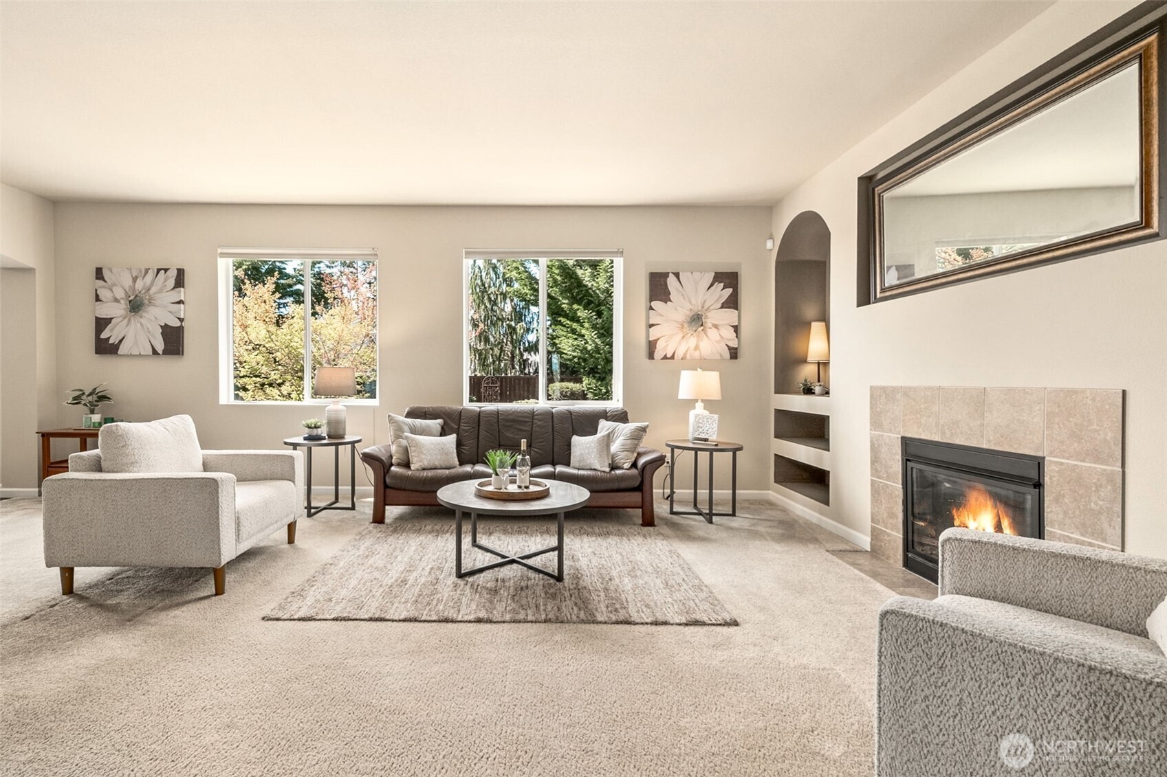 The tiled gas fireplace is flanked by arched, recessed built-in shelving, with plug-ins for specialty lighting.