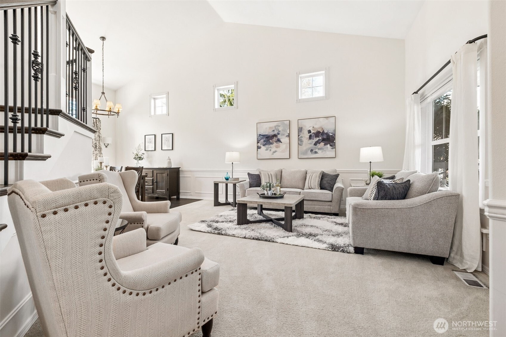 Impressive living room with soaring ceilings, high-set accent windows, and abundant natural light, offering a bright, open space ideal for both relaxing and entertaining.