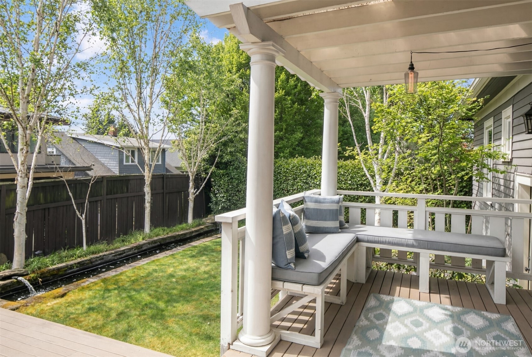 West-facing sunny back deck opens to lush level yard with pond.