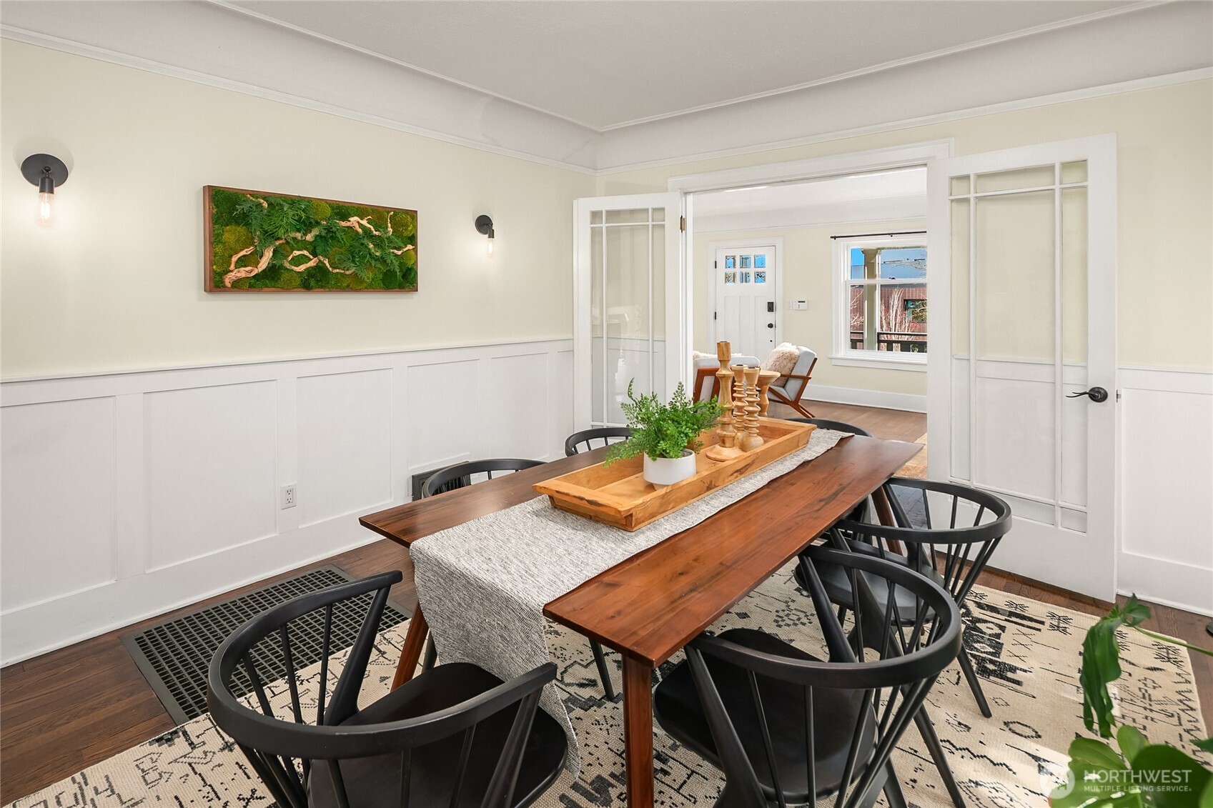 Dining room with wall of windows looks out to lush greenery.