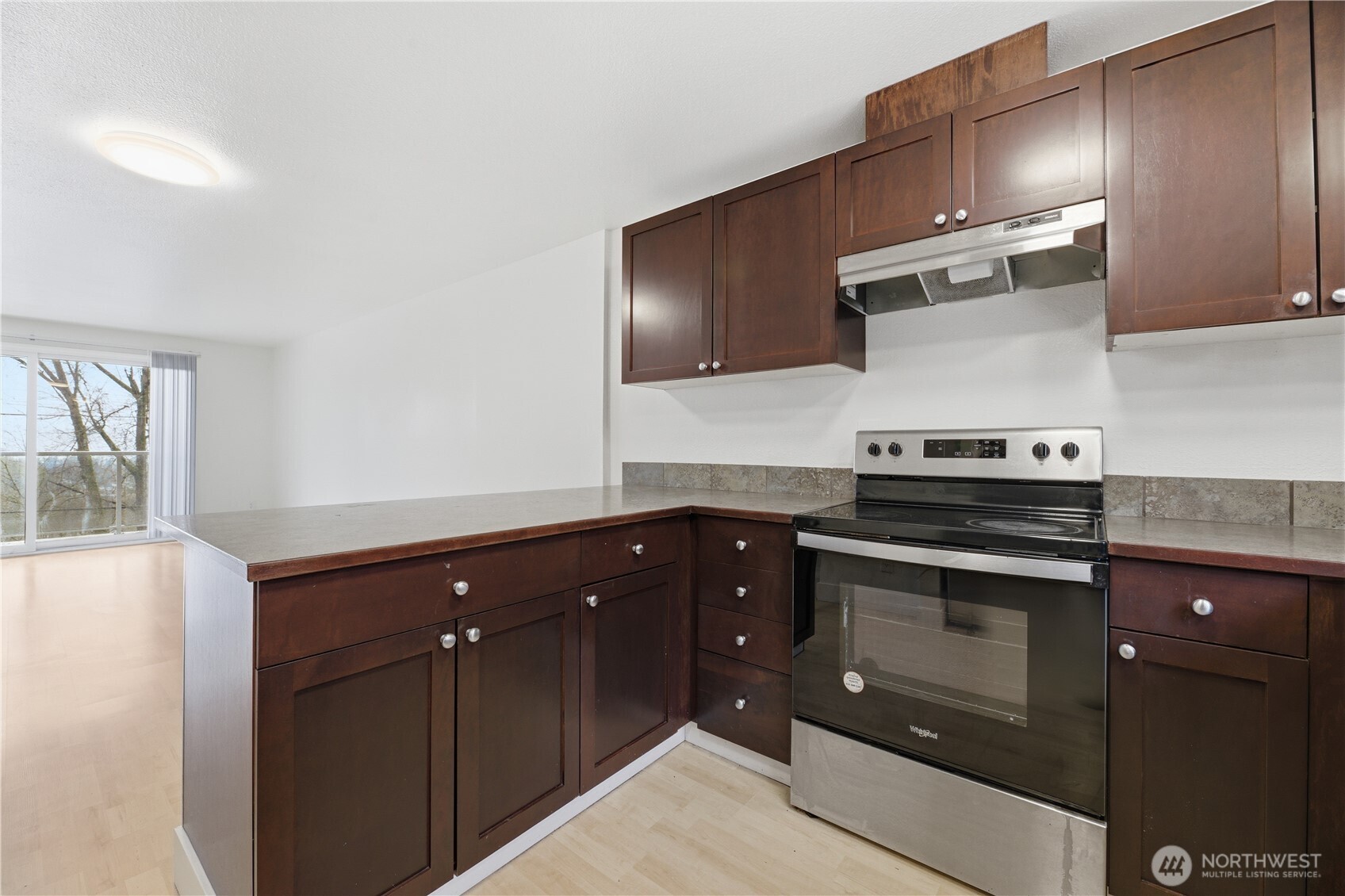 The open-style kitchen, adorned with rich-colored cabinetry & gleaming stainless-steel appliances, is perfectly situated for both practicality & style.