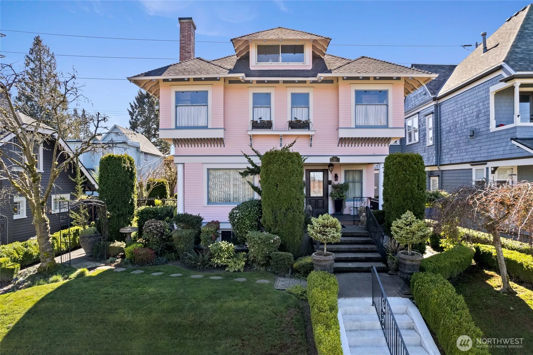 Dream Four Square in Tacoma’s North Slope Historic District.  Distinguished façade captivates with carved rafters & grand approach leading to expansive covered front porch adorned with statuary  & symmetrical plantings..
