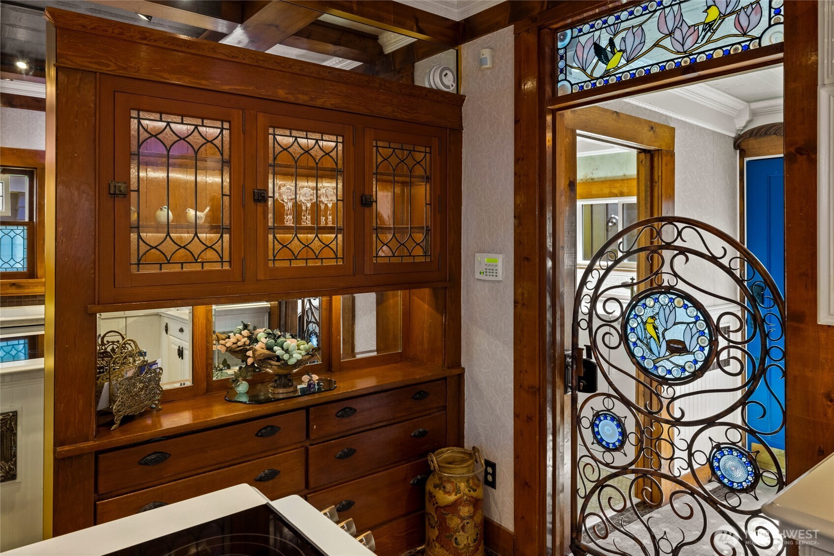 Sliding copper gate with glass details leads to full bathroom & pneumatic elevator off the kitchen.