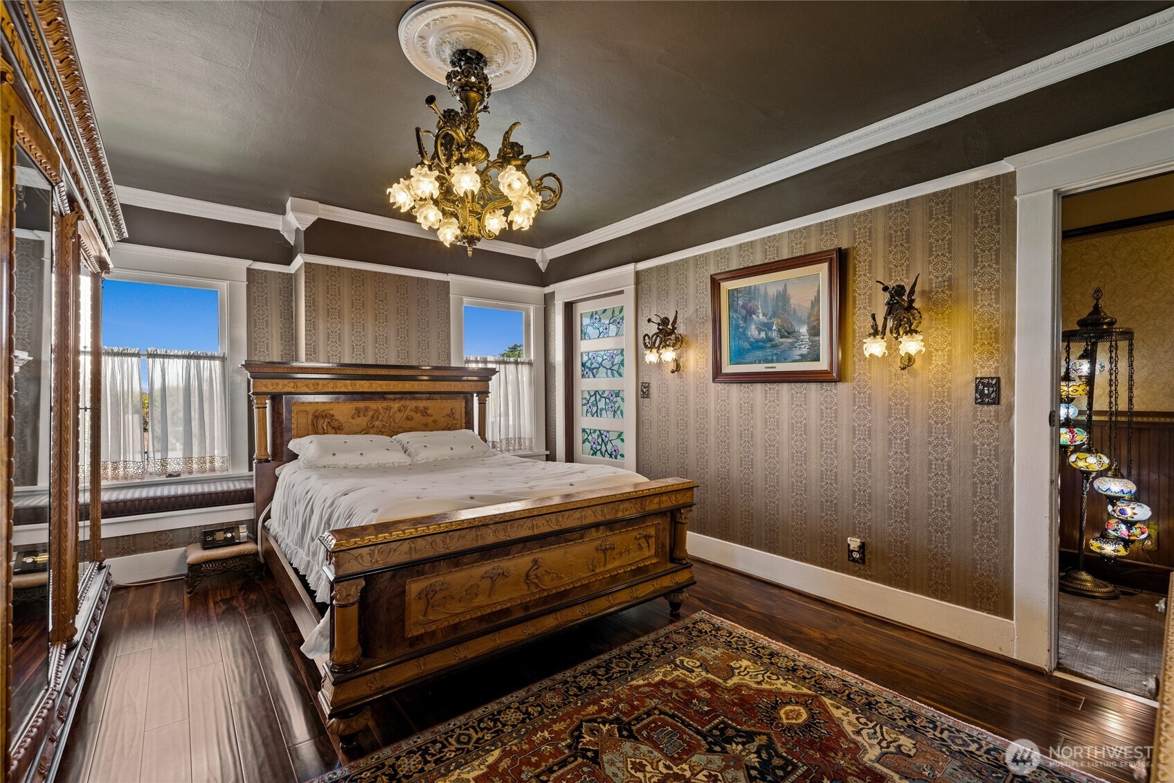 Striking bedroom on the second floor with hand cast chandelier & wall sconces.