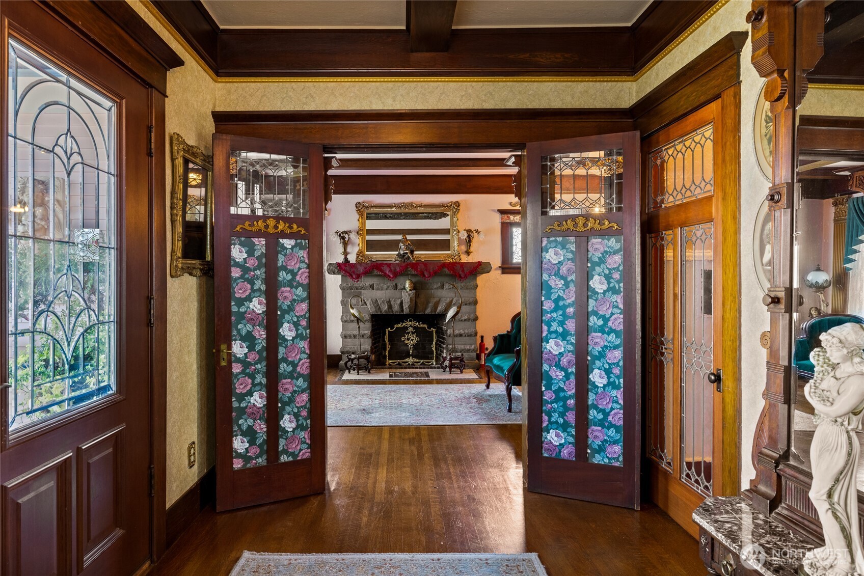 Entry with front door to the left has original woodwork in place. French doors to the front parlor with leaded glass.