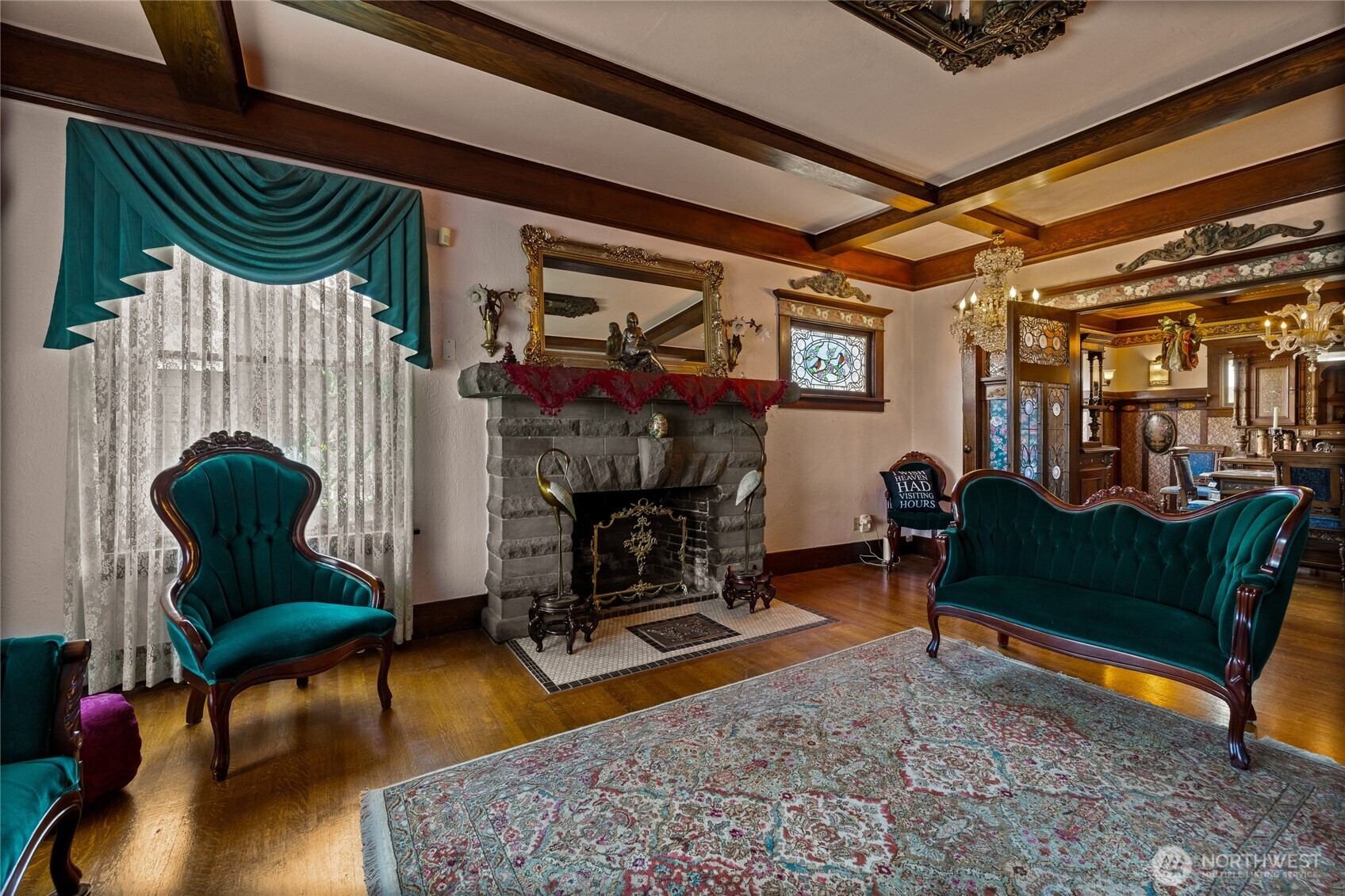 Spacious grand front parlor anchored with stone fireplace & box beam ceilings.