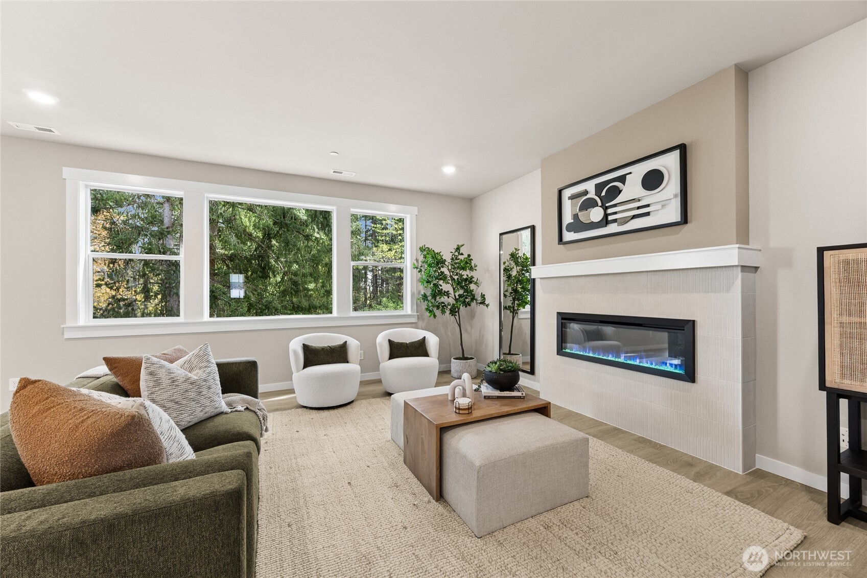 Cozy living room featuring sleek electric fireplace and abundant natural lighting.