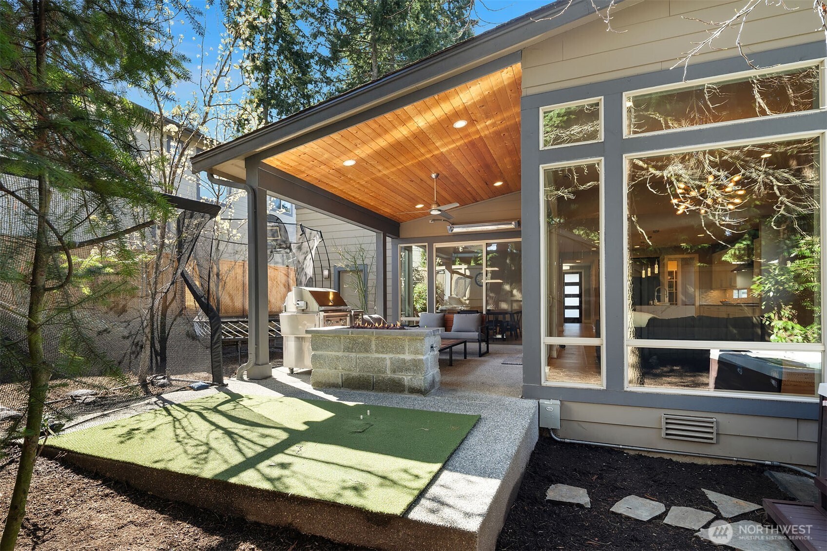 Fully fenced, low-maintenance backyard has Aqua Quip Hot Tub, Trampoline and Golf practice mat (all are staying)